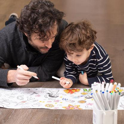 Man and child coloring the festivals of India coloring roll together on a wooden floor with markers.